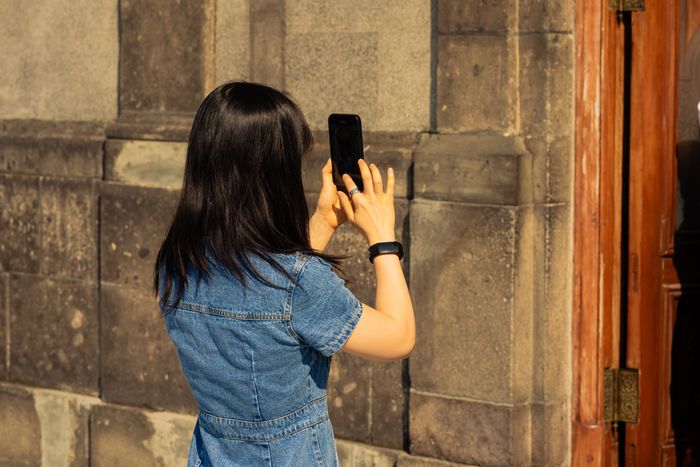 Someone photographing a wall with their phone to document its condition