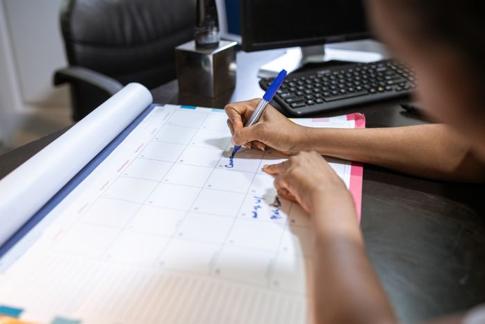 Someone marking a date on a desk calendar