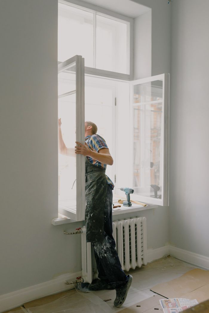 A tradesman installing a window in an apartment